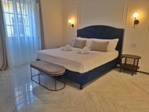 a bedroom with a large bed with a blue headboard at Marmori Suites Cagliari in Cagliari