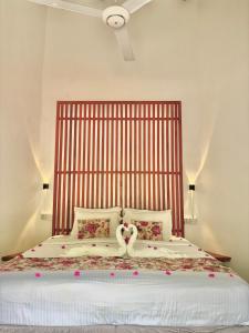 a bedroom with a large bed with a large headboard at Moon Isle Beach Bungalow in Nilaveli