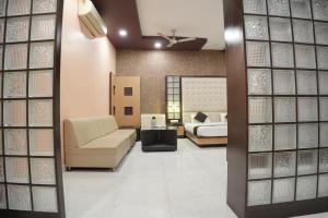 a room with a bed and a couch and a bedroom at Hotel Vishnu Vilas in Rewa