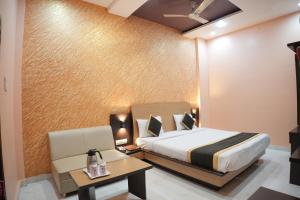 a bedroom with a bed and a table and a chair at Hotel Vishnu Vilas in Rewa +39 photos