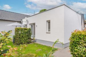a white house with a garden and an umbrella at Ferienhaus Kuschelnest in Kamminke