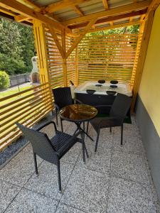a patio with chairs and a table and a grill at Počitniška hiša ˇGORICEˇ in Moravske-Toplice