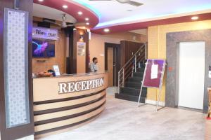 a woman standing at a reception counter in a building at Hotel Vishnu Vilas in Rewa