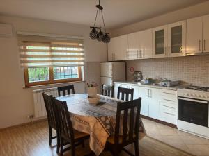 a kitchen with a table and chairs and a kitchen with white cabinets at Vila Sultan Sarajevo in Sarajevo