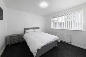 a white bedroom with a bed and a window at Henley Haven in Pelton Fell