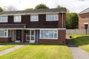 a red brick house with a white door at Henley Haven in Pelton Fell
