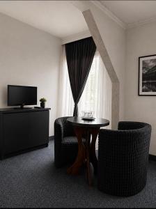 a living room with a table and chairs and a television at Pensiunea La Busu in Bran