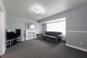 a living room with a couch and a television at Henley Haven in Pelton Fell