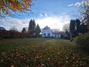 a white house in a yard with leaves on the grass at Trentsee Chalet in Malente