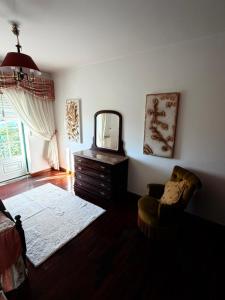 a living room with a mirror and a chair at Vio's Home in Serra de El-Rei