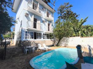 a hotel with a swimming pool in front of a building at Flats D'amoras em Conservatória sem café da manhã in Conservatória