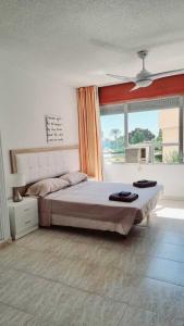 a bedroom with a large bed and a large window at Pequeño estudio frente al mar, piscina y parking in Villajoyosa +11 photos