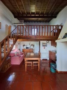a living room with a table and a staircase at Cabana do Compadre in Vila Nova da Baronia