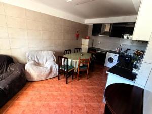 a kitchen and living room with a table and a couch at Vio's Home in Serra de El-Rei +18 photos