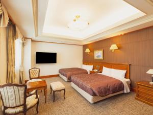 a hotel room with two beds and a television at Racine Shinmaebashi in Maebashi +33 photos