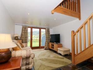 a living room with a couch and a television at Longside in Abergavenny