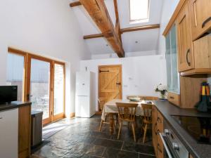 a kitchen with a table and a white refrigerator at Longside in Abergavenny