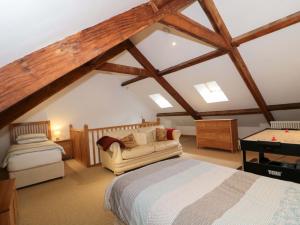 a attic bedroom with a bed and a couch at Longside in Abergavenny