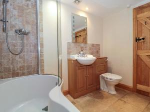 a bathroom with a tub and a sink and a toilet at Longside in Abergavenny +22 photos