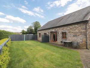 a stone house with a yard in front of it at Longside in Abergavenny