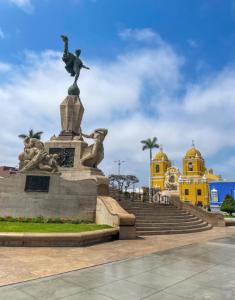 a statue in front of a building with stairs at SANCA HOUSE Hostel in Trujillo