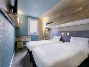 two beds in a room with blue walls at Ibis Budget Perpignan Sud in Perpignan +53 photos