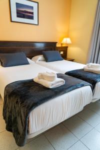 two beds in a hotel room with towels on them at CT Las Tres Palmeras - Valle Gran Rey in Valle Gran Rey