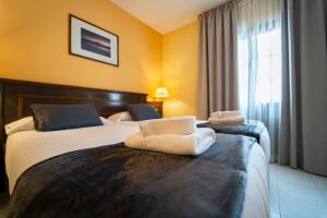 a hotel room with two beds with towels on them at CT Las Tres Palmeras - Valle Gran Rey in Valle Gran Rey