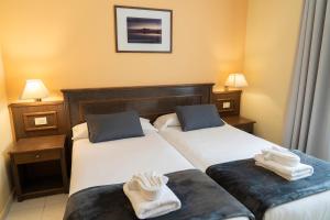 two beds in a hotel room with towels on them at CT Las Tres Palmeras - Valle Gran Rey in Valle Gran Rey