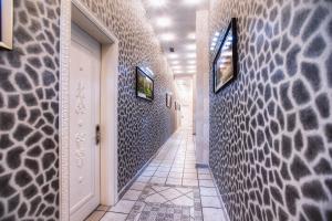 a hallway with a white door and a tile wall at Admiral Hotel in Baku