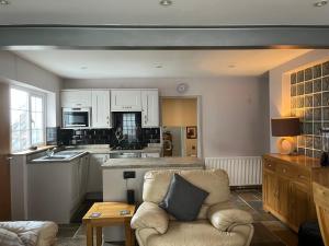a living room with a couch and a kitchen at Stunning coastal cottage in Worle