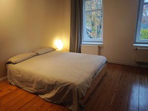 a bed in a bedroom with two windows at Trentsee Chalet in Malente