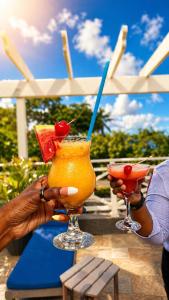 two people holding two cocktails on a table at Manta Lodge and Dive Centre in Speyside