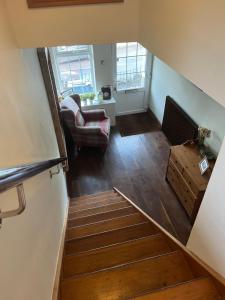 a stairway leading to a living room with a chair at Stunning coastal cottage in Worle