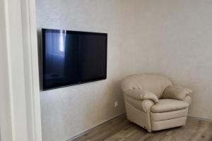 a chair in a room with a flat screen tv on the wall at СічSich in Kolomiya