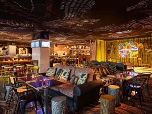 a restaurant with couches and tables and a bar at Mama Shelter Paris East in Paris