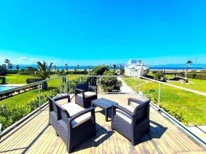 a deck with chairs and a table and a view of the ocean at Psalidi beach house in Psalidi