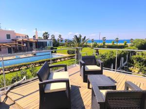 a group of chairs and tables on a deck at Psalidi beach house in Psalidi