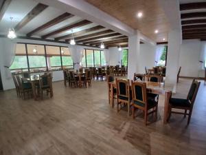 a dining room with tables and chairs and windows at Hanul Ibăștean in Brădeţelu