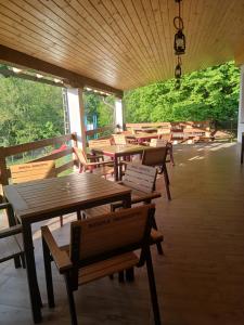 a restaurant with wooden tables and benches and plants at Hanul Ibăștean in Brădeţelu