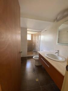 a bathroom with a sink and a toilet at Beach View Palace in Porlamar
