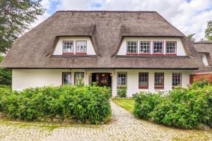 a large white house with a thatched roof at Seestern in Vollerwiek