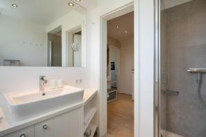a white bathroom with a sink and a shower at Silwai OG in Westerland +14 photos