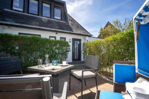 a patio with a table and chairs in front of a house at Silwai OG in Westerland