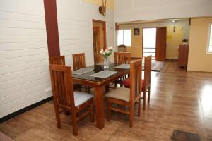 a dining room with a wooden table and chairs at sunshine retreat in Coonoor