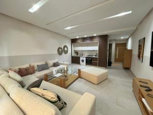 a living room with a couch and a table at Charming Seaside Apartment with Pool & Direct Beach Access in Agadir nʼ Aït Sa