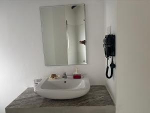a bathroom with a white sink and a mirror at Moon Isle Beach Bungalow in Nilaveli