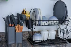 a shelf with plates and utensils on a counter at The Comfort Den in Kampala