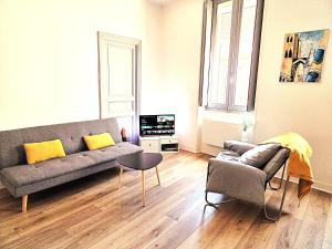 a living room with a couch and a table at Hypercentre Capitole T2 vaste et lumineux in Toulouse
