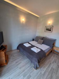 a bedroom with a bed with two towels on it at Apartamenty Obok Ruin in Trzęsacz